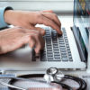 doctor’s hands using laptop at medical office